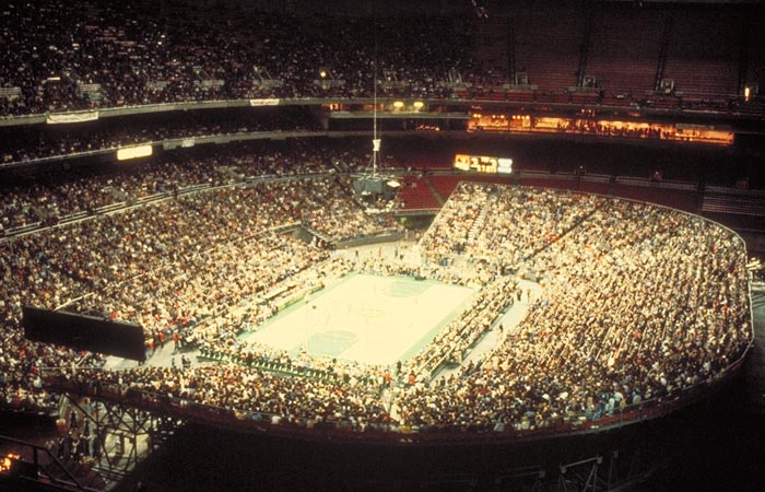 A basketball game in front of a packed Kingdome crowd